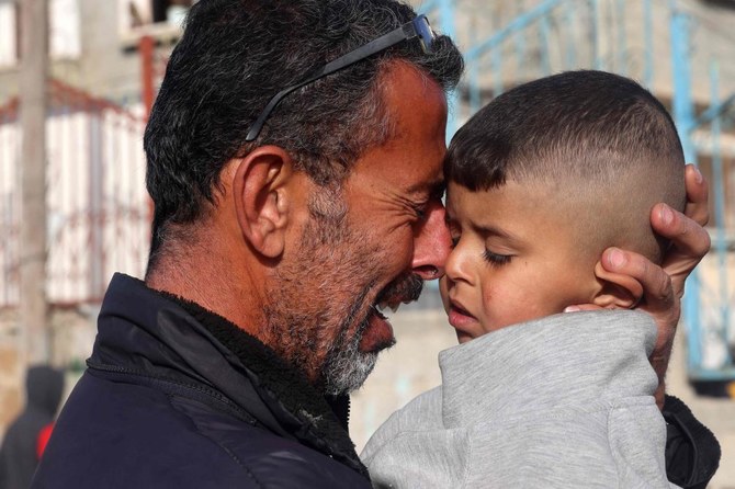 A Palestinian man holds a child as he mourns the death of twin babies Naeem and Wissam, killed in an overnight Israeli air strike, during their burial in Rafah in the southern Gaza Strip as the conflict between Israel and the Palestinian militant group Hamas continues. (File/AFP)