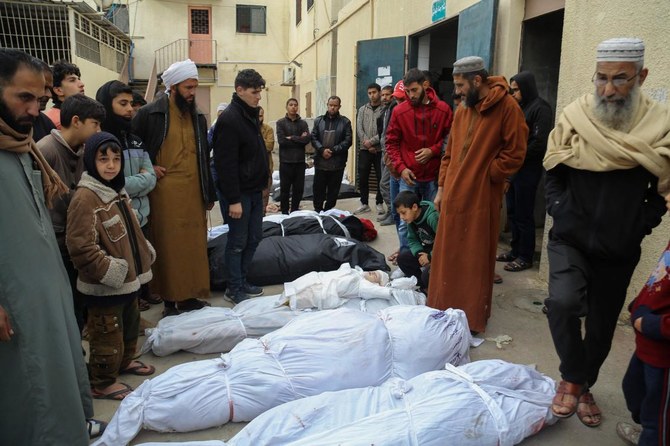 Palestinians mourn at the Al-Aqsa Martyrs Hospital in Deir Al-Balah next to bodies of victims pulled from the rubble of the Tabatibi family home on Mar, 16, 2024, following overnight Israeli bombardment west of the Nuseirat refugee camp in the central Gaza Strip. (AFP)