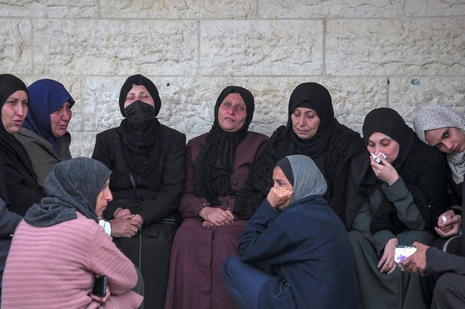 Palestinians mourn at the Al-Aqsa Martyrs Hospital in Deir Al-Balah next to bodies of victims pulled from the rubble of the Tabatibi family home on Mar, 16, 2024, following overnight Israeli bombardment west of the Nuseirat refugee camp in the central Gaza Strip. (AFP)