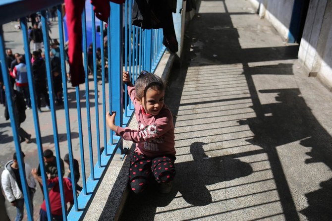 A young girl sits on the balcony of an UNRWA school housing displaced Palestinians, Rafah, southern Gaza Strip, Mar. 4, 2024. (AFP)