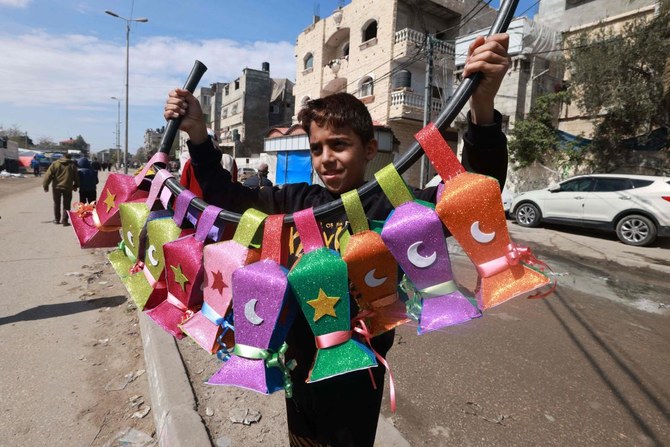 A displaced Palestinian child sells handmade Ramadan lanterns in Rafah in the southern Gaza Strip on Mar. 8, 2024, as Muslim worshippers prepare to welcome the holy fasting month of Ramadan which begins next week. (AFP)