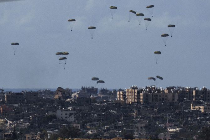 Parachutes drop supplies into the northern Gaza Strip, as seen from southern Israel, on March 8, 2024. (AP Photo/Leo Correa)