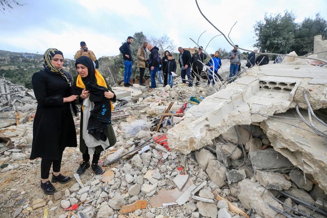 People inspect the rubble of a house where Hezbollah member Hassan Hussein and his family were killed a day earlier in an Israeli bombardment on March 6, 2024. (AFP)