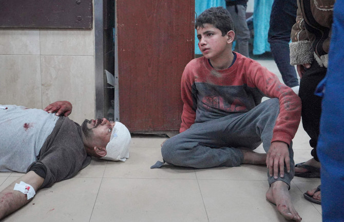 A Palestinian youth keeps company to an injured relative receiving care at the Al-Aqsa Martyrs Hospital after Israeli bombardment hit the al-Atrash family home in Deir Al-Balah in the central Gaza Strip on March 12, 2024, amid ongoing battles between Israel and the Palestinian militant group Hamas. (AFP)