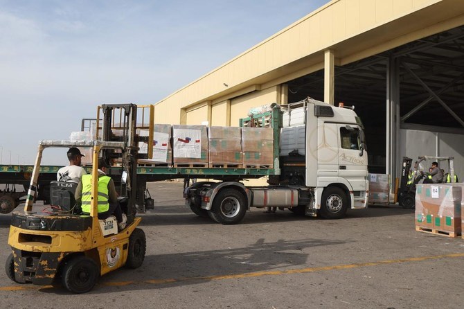 Trucks carry boxes from a joint French Qatari humanitarian aid package to Gaza arrived from Doha in Egypt’s El-Arish airport. (AFP)