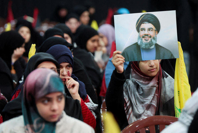 A supporter of Lebanon’s Hezbollah leader Sayyed Hassan Nasrallah holds his picture during a rally commemorating the group’s late leaders in Beirut’s southern suburbs, Lebanon February 16, 2024. (REUTERS)