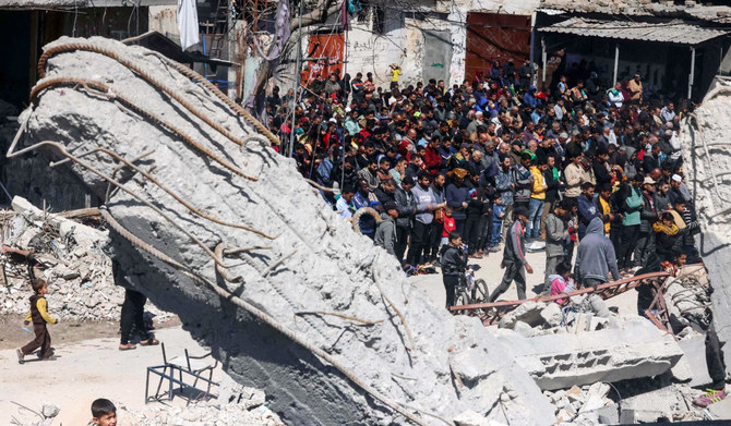 Palestinians perform the first Friday noon prayer of the Muslim holy fasting month of Ramadan in front of the ruins of Al-Farouq Mosque on March 15, 2024, destroyed in Israeli bombardment in Rafah in the southern Gaza Strip, amid ongoing battles between Israel and the militant group Hamas. (AFP)