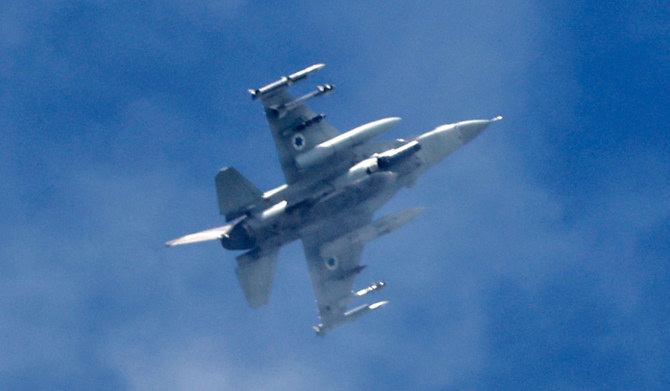 This picture taken from a position in northern Israel shows an Israeli Air Force fighter jet flying over the border area with south Lebanon on March 10, 2024, amid increasing cross-border tensions between Lebanon's Hezbollah and Israel as fighting continues with Hamas militants in the Gaza Strip. (AFP)