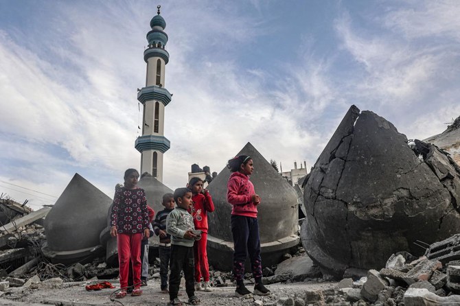 Children stand next to the rubble of Al-Faruq Mosque, that was destroyed during Israeli bombardment, in Rafah on the southern Gaza Strip on March 17, 2024, amid ongoing battles between Israel and the Palestinian militant group Hamas. (AFP)