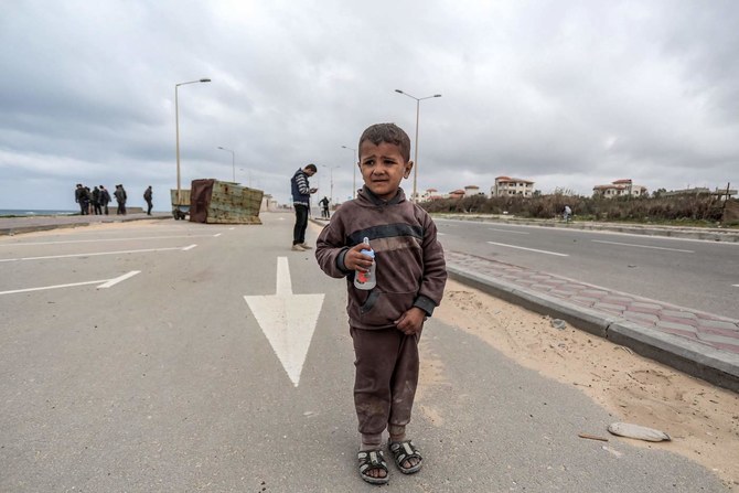 A child walks along the coastal highway with other displaced Palestinians fleeing from the area in the vicinity of Gaza City’s Al-Shifa hospital. (AFP)