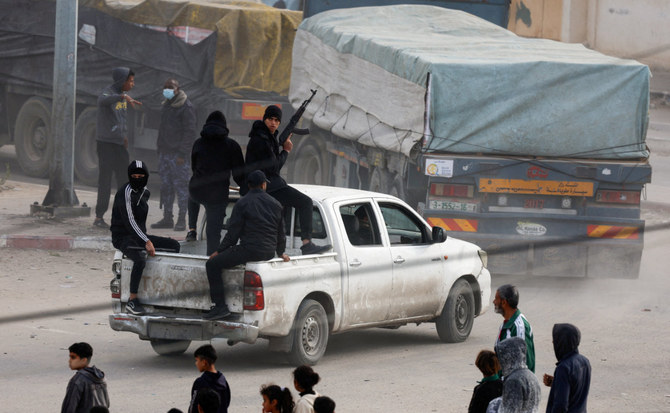 Security personnel guard trucks carrying aid as they arrive in Rafah, amid the ongoing conflict between Israel and the Palestinian Islamist group Hamas, in the southern Gaza Strip. (Reuters)