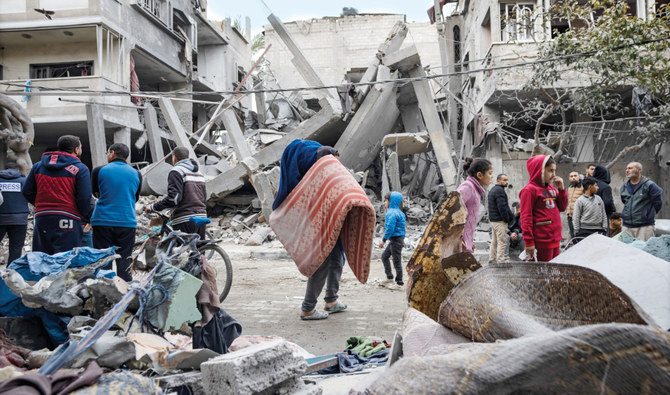 Distressed Palestinians inspect the damage of residential buildings after an Israeli airstrike in Rafah, southern Gaza Strip, on Sunday. (AFP)