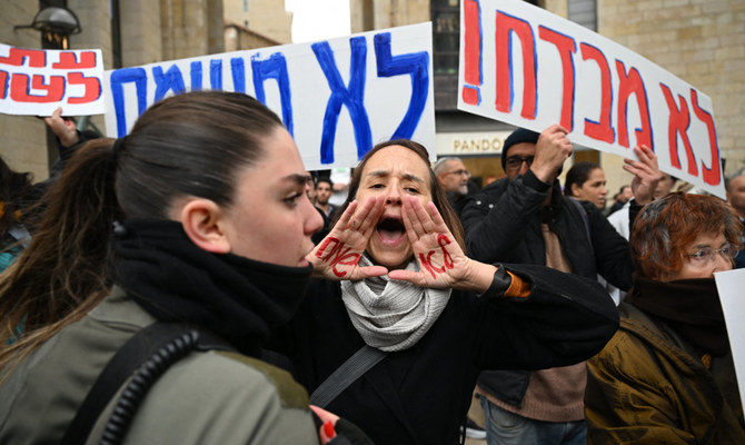 Israeli police stand guard as relatives of Israeli hostages held in Gaza since the October 7 attacks by Hamas militants, gather in protest during a Purim parade in Jerusalem on March 25, 2024. (AFP)