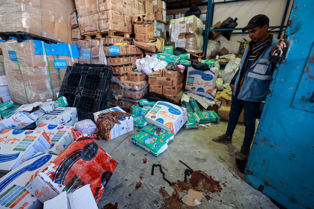 A UN staff stands near a pool of blood at an UNRWA warehouse and distribution centre in Rafah, in the southern Gaza Strip, following an Israeli strike on March 13, 2024. (AFP)