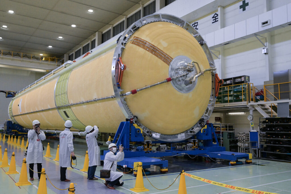 Journalists take imagery of a rocket core on the floor of the no. 2 assembly shop during a media tour by Mitsubishi Heavy Industries and the Japan Aerospace Exploration Agency (JAXA). (AFP)