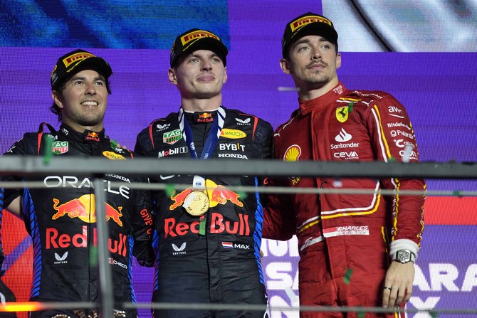 Winner Red Bull driver Max Verstappen of the Netherlands, center, celebrates on the podium flanked by second place Red Bull driver Sergio Perez of Mexico, led, and third place Ferrari driver Charles Leclerc of Monacoon the podium of the Formula One Saudi Arabian Grand Prix at the Jeddah Corniche Circuit, in Jedda, Saudi Arabia, Saturday, March 9, 2024. (AP)