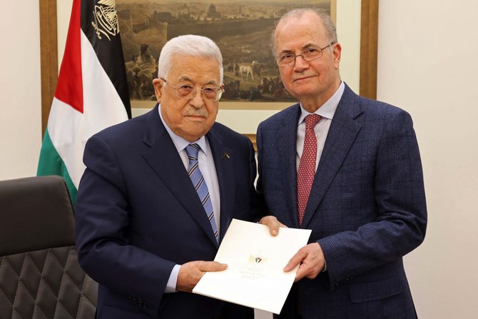 Handout picture provided by the Palestinian Authority's Press Office (PPO) shows Palestinian President Mahmud Abbas (L) posing with the newly appointed Palestinian Prime Minister Mohammad Mustafa (AFP)