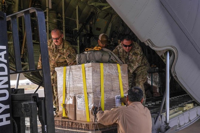 Members of the US Air Force 26th Expeditionary Rescue Squadron load an HC-130J aircraft at an airbase in Jordan, before flying toward the Gaza Strip on a mission to airdrop humanitarian aid supplied by Jordan on Mar. 14, 2024. (AFP)