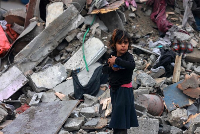 A young Palestinian girl stands amid the rubble of a building hit by overnight Israeli bombardment in Rafah in the southern Gaza Strip on March 24, 2024. (AFP)