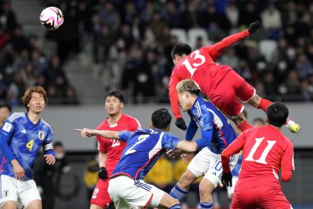 Japan and North Korea players tussle for the ball during their FIFA World Cup 2026 and AFC Asian Cup 2027 preliminary joint qualification round 2 match at the National Stadium on Thursday, March 21, 2024, in Tokyo. (AP)