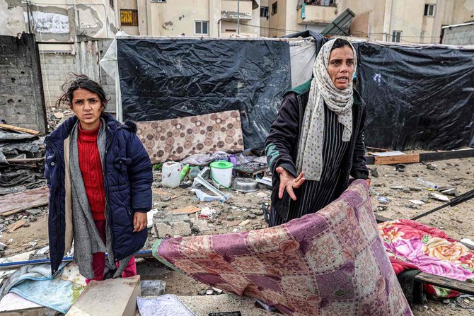 A woman reacts while standing before shelters erected outside a damaged building following overnight Israeli bombardment at Rafah refugee camp in southern Gaza Strip on March 19. (AFP)