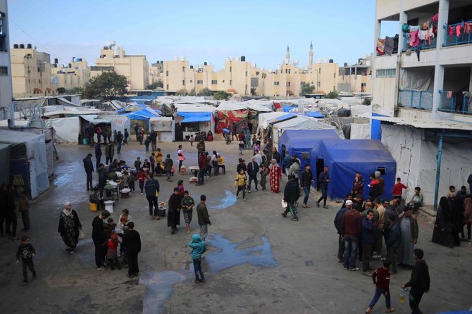 Displaced Palestinians walk around in an UNRWA school housing displaced Palestinians, in Rafah in the southern Gaza Strip on March 4, 2024. (AFP)