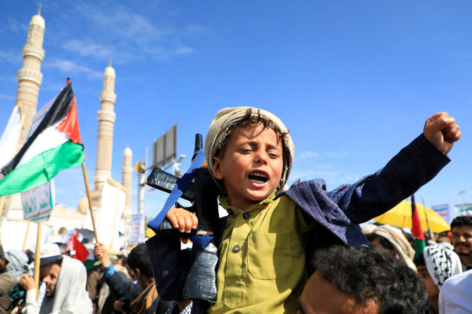 A Yemeni child carries a weapon and chants slogans during a march in the Houthi-run capital Sanaa on March 22, 2024. (AFP)
