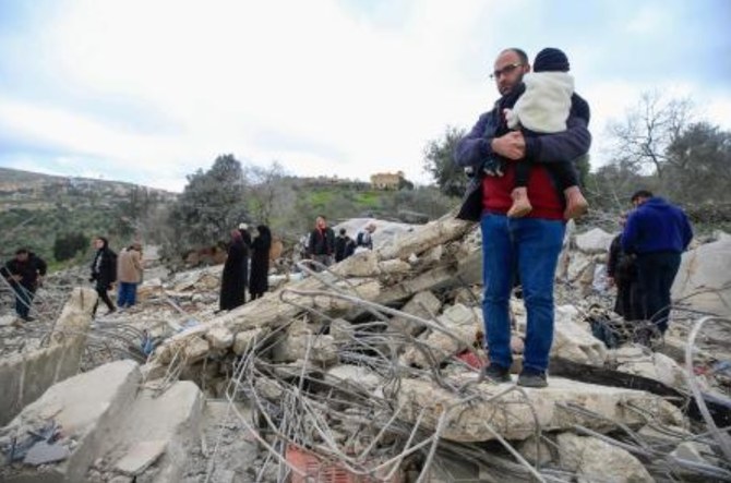 People inspect the rubble of a house where Hezbollah member Hassan Hussein, his wife Ruwaida Mustafa, and their 25-year-old son Ali Hussein, were killed a day earlier in Israeli bombardment, following their funeral in their southern Lebanese village of Houla on Mar. 6, 2024. (AFP)