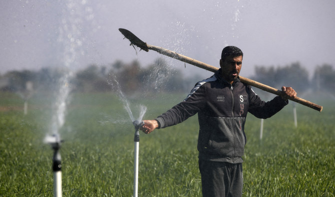 A farmer adjusts a sprinkler, part of a new water management systems brought by the UN World Food Programme, on his farm in the village of Al-Azrakiya, in Iraq's central province of Anbar, on February 22, 2024. (AFP)