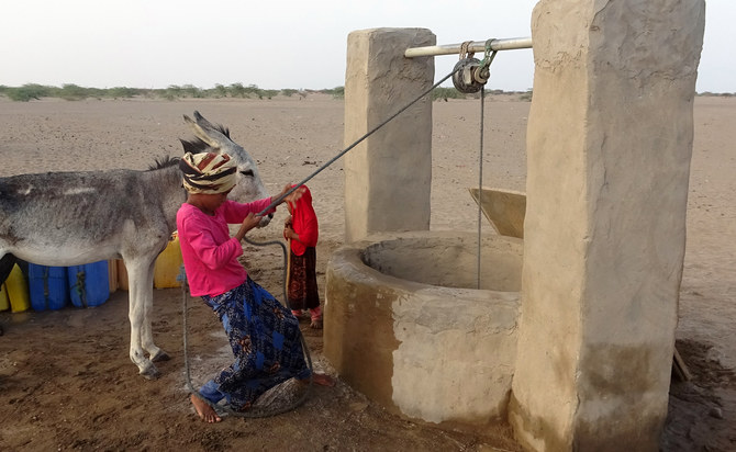 A Yemeni girl pulls out a bucket of water from a well, at a makeshift camp for people who fled fighting between Houthi rebels and the Saudi-backed government forces. (AFP/file)