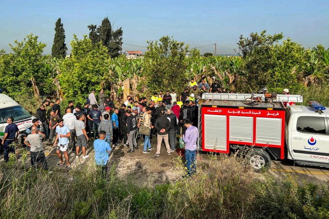 People gather at the site of an Israeli strike on a vehicle in the Adloun plain area, between Lebanon’s southern cities of Sidon and Tyre, Apr. 23, 2024. (AFP)