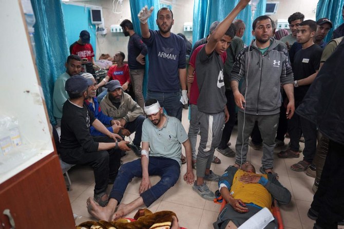 Injured Palestinian men lie on the floor at the Al-Aqsa Martyrs Hospital in Deir al-Balah in the central Gaza Strip, following Israel bombardment on March 31, 2024. (AFP)