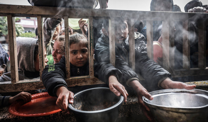 Displaced Palestinian children gather to receive food at a government school in Rafah in the southern Gaza Strip on February 19, 2024. (AFP)