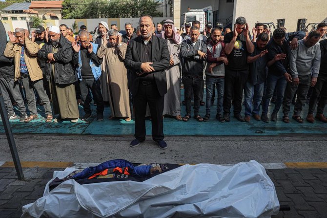 Relatives and friends pray by the body of Saif Abu Taha, a staff member of the US-based aid group World Central Kitchen who was killed as Israeli strikes hit a convoy of the NGO delivering food aid in Gaza, during his funeral in Rafah on Apr. 2, 2024. (AFP)