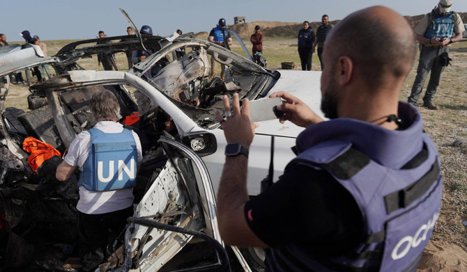 United Nations staff members inspect the carcass of a car used by US-based aid group World Central Kitchen, that was hit by an Israeli strike the previous day in Deir al-Balah in the central Gaza Strip on April 2, 2024, amid the ongoing battles between Israel and the Palestinian militant group Hamas. (AFP)