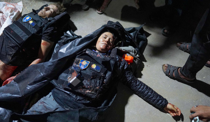 People gather around the bodies of World Central Kitchen workers at Al-Aqsa Hospital in Deir al-Balah, Gaza Strip, on April 1, 2024, amid the ongoing battles between Israel and the Palestinian militant group Hamas. (AFP)