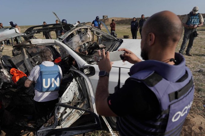 United Nations staff members inspect the carcass of a car used by US-based aid group World Central Kitchen, that was hit by an Israeli strike the previous day in Deir al-Balah in the central Gaza Strip on Apr. 2, 2024. (AFP)