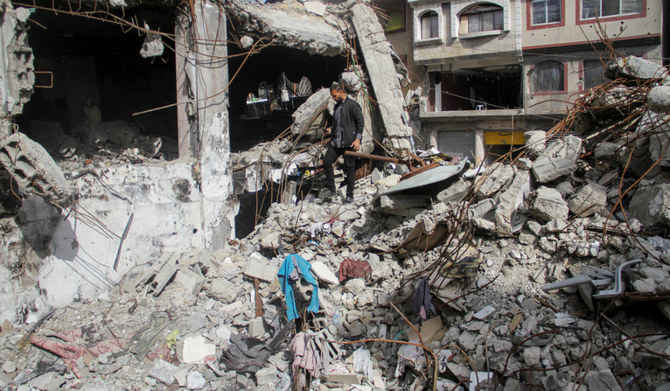 Palestinian owner of mobile phone business Salem Awad Rab’a walks through the rubble of his shop in Jabalia in the northern Gaza Strip. (Reuters)