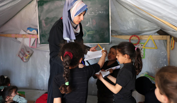 A teacher speaks to students at a makeshift classroom in a camp for displaced Palestinians in Rafah in the southern Gaza Strip. (AFP)