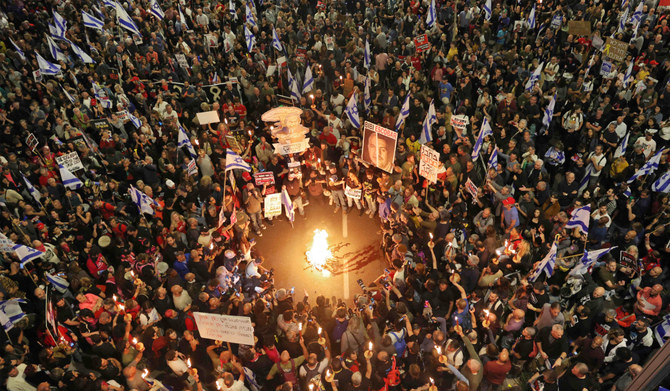 Relatives and supporters of Israeli hostages held in Gaza since the October 7 attacks by Hamas militants hold placards and wave Israeli flags during a demonstration in front of the Defence Ministry in the Israeli coastal city of Tel Aviv, on April 6, 2024, amid the ongoing conflict in the Gaza Strip between Israel and the Palestinian militant Hamas movement. (AFP)