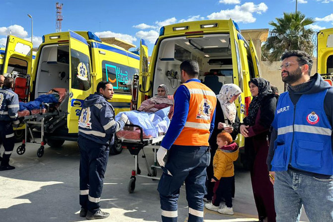 Injured Palestinians transported into Egyptian Red Crescent ambulance vehicles after evacuation from the Gaza Strip via the Rafah border crossing into Egypt on February 1, 2024. (AFP)