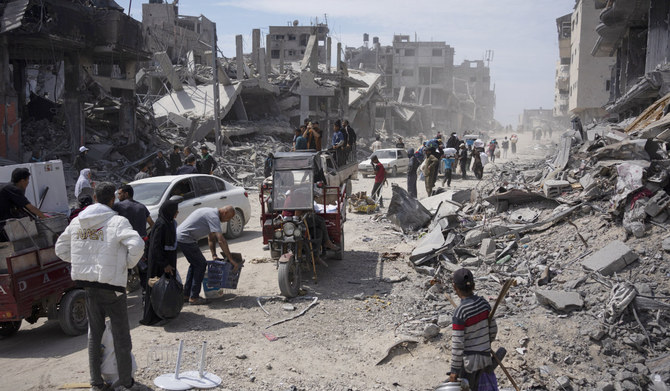 Palestinians walk through the destruction in the wake of an Israeli air and ground offensive in Khan Younis, southern Gaza Strip, amid the conflict between Hamas and Israel. (AP)