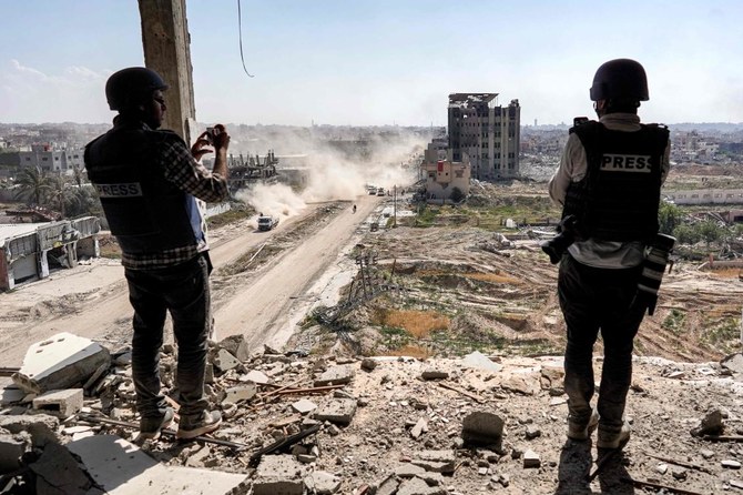 Journalists film from atop a damaged building facing the ravaged building of al-Salam hospital in Khan Yunis on April 7, 2024 after Israel pulled its ground forces out of the southern Gaza Strip. (AFP)
