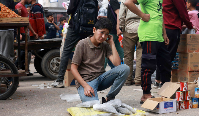 A Palestinian child sells food items in a market, ahead of Eid al-Fitr celebrations which conclude the Muslim holy fasting month of Ramadan, in Rafah in the southern Gaza Strip on April 5, 2024 amid the ongoing conflict between Israel and the militant group Hamas. (AFP)