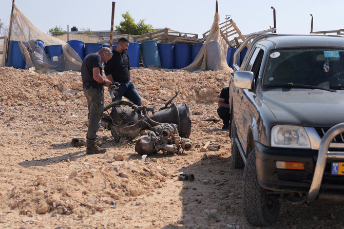 A police officer inspects the remains of a rocket booster near Arad, Israel on April 14, 2024.(Reuters)