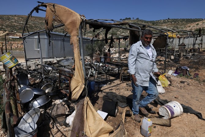 A Palestinian inspects the damage to his belongings in the village of Mughayir near Ramallah in the Israeli-occupied West Bank on April 13, 2024, after an attack by Israeli settlers on the village (AFP)