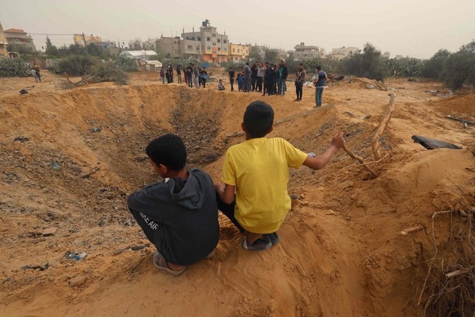 Two Palestinian boys look a huge crater following overnight Israeli bombardment in Rafah in the southern Gaza Strip on April 18, 2024, amid the continuing conflict between Israel and Hamas. (AFP)