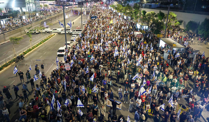 Relatives and supporters of Israeli hostages held in Gaza hold placards and wave Israeli flags during a demonstration in front of the Defense Ministry in Tel Aviv, on April 20, 2024. (AFP)