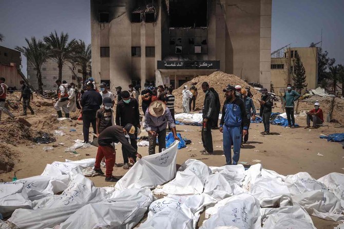 People and health workers unearth bodies found at Nasser Hospital in Khan Younis in the southern Gaza Strip on April 23, 2024. (AFP)