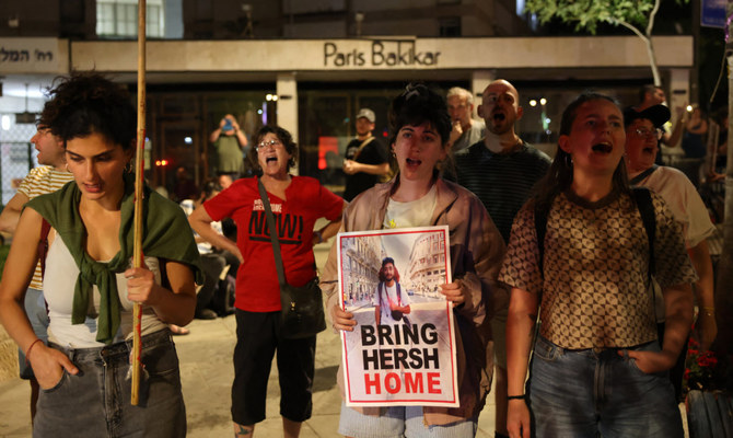 Relatives and supporters of Israeli hostages held in Gaza since the October 7 attacks by Hamas militants, hold a poster with the image of Israeli American hostage Hersh Goldberg-Polin, 23, as they protest near the residence of the Israeli prime minister calling for their release in Jerusalem on April 24, 2024. (AFP)